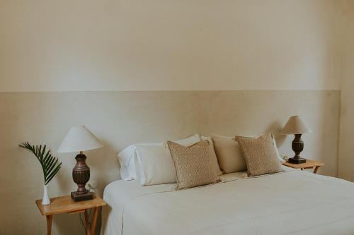 a bedroom with a white bed with two lamps at Villa Gardenia - Oceanfront Casa Cactus in Todos Santos