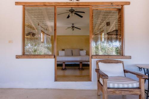 a room with a window and a chair and a couch at Villa Gardenia - Oceanfront Casa Cactus in Todos Santos