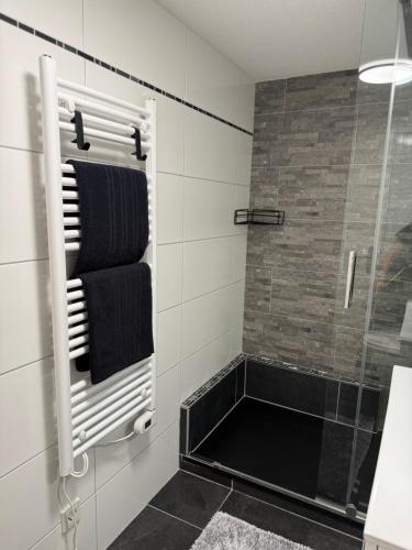a bathroom with a shower and a black towel rack at Ferienwohnung für Gruppen oder Familien in Schönwies