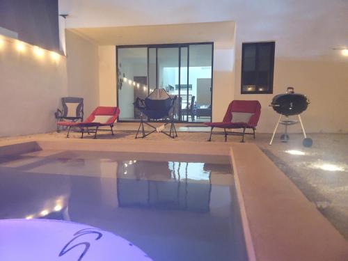 a pool in a room with chairs and a table at Beautiful House Private Pool 2 min Sitpach Family 