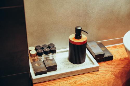 a table with a bottle of perfume and other items at Strindberg Boutique Hotel in Topliţa