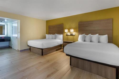 a hotel room with two beds and a bathroom at SureStay by Best Western Chambers Petrified Forest in Chambers
