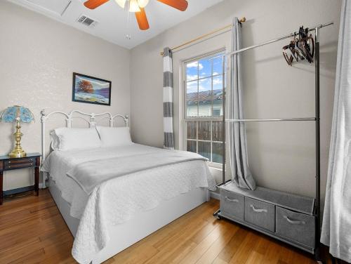 a white bedroom with a bed and a window at 6 min from River center mall and hospital in San Antonio