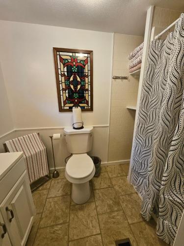 a bathroom with a toilet and a stained glass window at Imma Place in Trenton