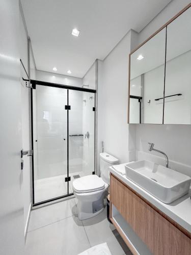 a bathroom with a toilet and a sink and a shower at Flat Relicário com Linda Vista da Cidade in Campo Grande