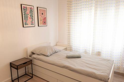 una piccola camera da letto con un letto e una finestra di Appart 10 pers - Lille Lambersart - Parking & Terrasses a Lambersart