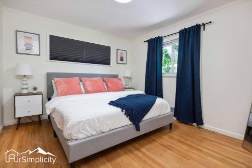 a bedroom with a bed with orange and blue pillows at Peaceful home with fire pit and game room in Denver