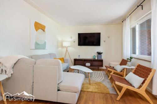 a living room with a couch and a tv at Peaceful home with fire pit and game room in Denver