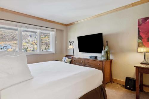 a bedroom with a bed and a flat screen tv at Lodge Tower 782 in Vail