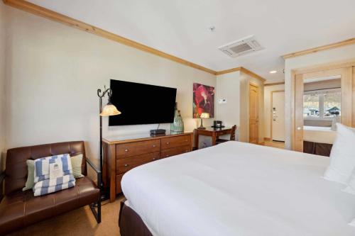 a bedroom with a bed and a tv and a chair at Lodge Tower 782 in Vail