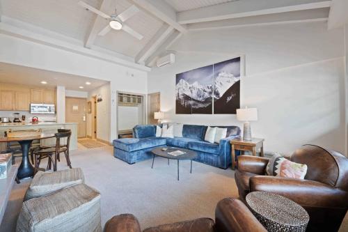 a living room with a blue couch and a kitchen at Lodge Tower 786 Two Bedroom Residence in Vail