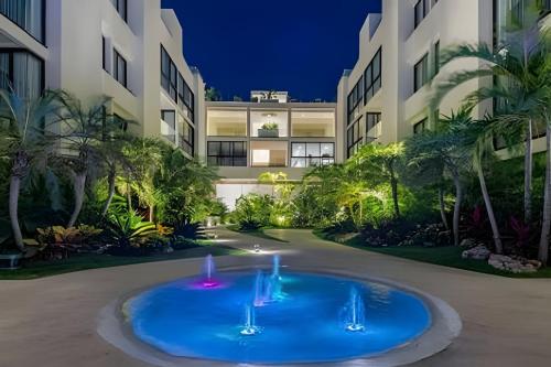una grande fontana blu di fronte a un edificio di Departamento de Lujo a Pasos de 5ta Avenida 208S a Playa del Carmen