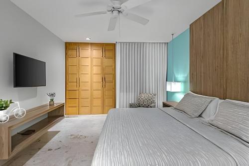 una camera da letto con un letto grande e una TV a schermo piatto di Departamento de Lujo a Pasos de 5ta Avenida 208S a Playa del Carmen
