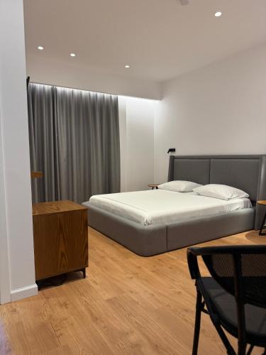 a bedroom with a bed and a chair and a table at Vironas Hotel in Himare