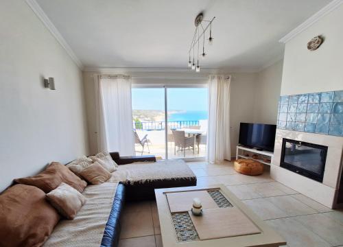 een woonkamer met een bank en een open haard bij Casa Calma in Salema