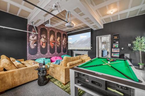 a living room with a pool table at 10 min to DT, Luxe 4BR w Movie Theater, Game Room in Commerce City