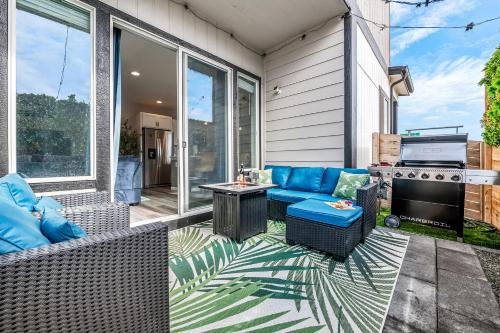 a patio with a blue couch and a grill at 10 min to DT, Luxe 4BR w Movie Theater, Game Room in Commerce City