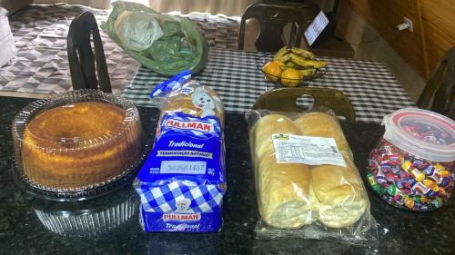 een tafel met brood en ander voedsel erop bij Chalé Bela Vista in Munhoz