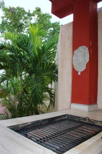 a porch with a red column and a grate at Casa Nicte-ha Valladolid in Valladolid