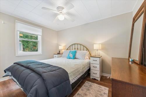 a bedroom with a bed and a ceiling fan at Bay & Birch Getaway - Lakefront Living in Wiarton