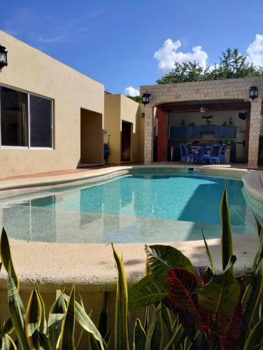 a swimming pool in front of a house at Casa Nicte-ha Valladolid in Valladolid