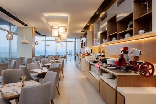 a restaurant with tables and chairs and a counter at AC Hotel By Marriott Santa Marta in Santa Marta