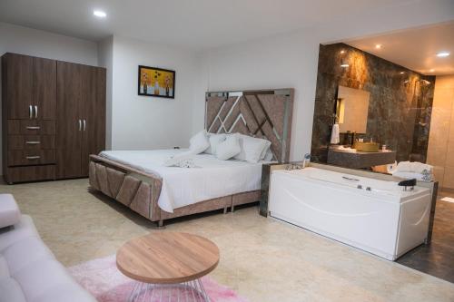 a bedroom with a bed and a tub in a room at Hotel Boutique Campestre in Florencia
