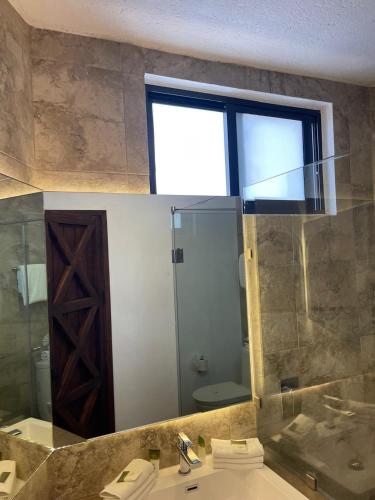 a bathroom with a sink and a large mirror at Hotel Maridelfi in Tequisquiapan