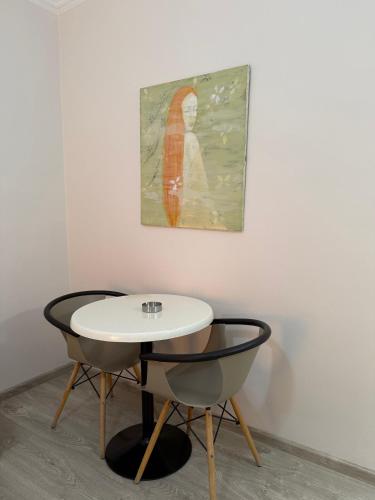 a table and two chairs in a room with a painting at Vironas Hotel in Himare
