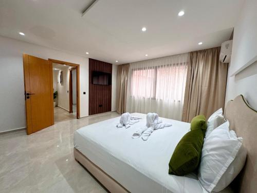 a bedroom with a large white bed with two animals on it at Chic duplex luxury3suites et wi-fi in Marrakech