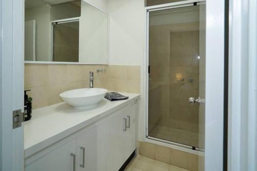 a white bathroom with a sink and a shower at Classic East Perth - Close To Optus Stadium in Perth