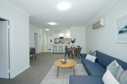 a living room with a blue couch and a table at Classic East Perth - Close To Optus Stadium in Perth