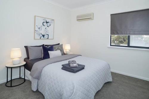 a white bedroom with a bed and a window at Classic East Perth - Close To Optus Stadium in Perth