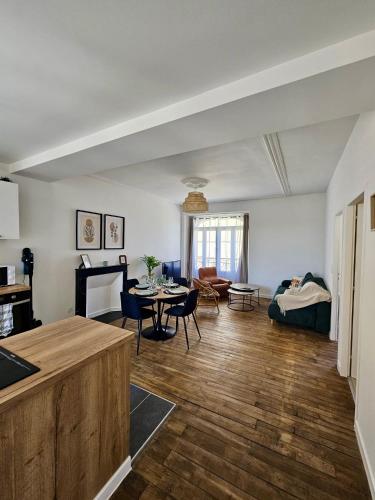 a kitchen and living room with a table and a couch at L'Authentique - Appartement 6 in Loudéac