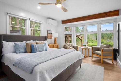 a bedroom with a large bed and windows at After Dune Delight, 5BR Home Near River in Glen Arbor