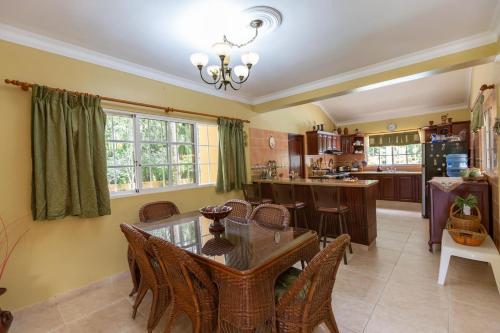a kitchen and dining room with a table and chairs at Huttub Dailycleaning Gacebo Bbq River in Bonao