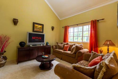 a living room with a couch and a tv at Huttub Dailycleaning Gacebo Bbq River in Bonao