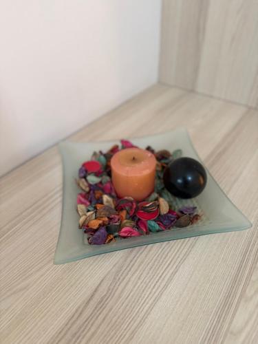 a candle sitting on a plate with some flowers at Vironas Hotel in Himare