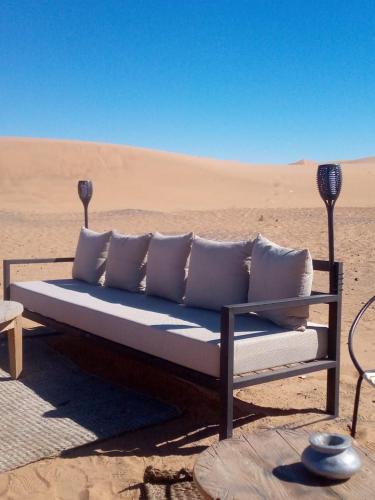 a couch sitting in the middle of the desert at Merzouga Desert Experience Camp-Erg Chebbi Sunset & Camel Ride in Merzouga