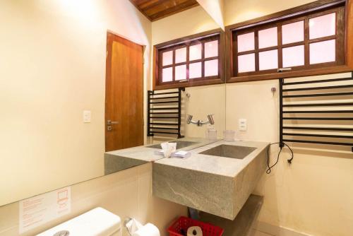 a bathroom with a large sink and a toilet at Casa Tubarão - Piscina Aquecida em Camburi in Camburi
