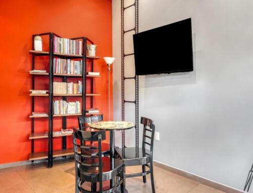 a dining room with a table and chairs and a tv at Hotel Arana Tonalá in Guadalajara