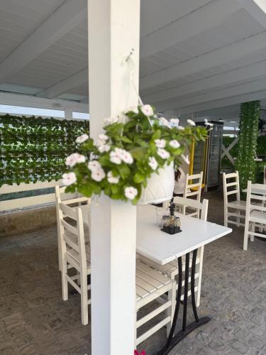 a white table with a bouquet of flowers on it at Vironas Hotel in Himare