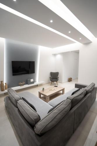a living room with a large couch and a tv at Luxury Apartment in Lamia in Lamía