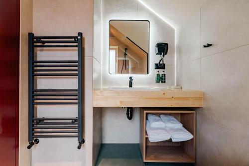 a bathroom with a sink and a mirror at Uphill Spa Chalets in Bran