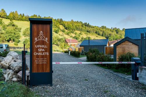 a sign on a gate in front of a house at Uphill Spa Chalets in Bran