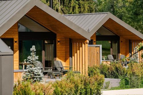 a log cabin with a porch and chairs in the yard at Uphill Spa Chalets in Bran
