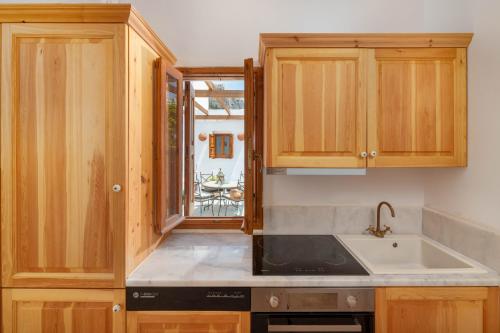Una cocina con gabinetes de madera y un fregadero. en Villa Vasoula Lindos, Jasmine and Gardenia Suite, en Lindos