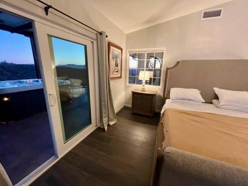 a bedroom with a bed and a large window at Ultimate Winery Getaway With Spa And Amazing Hilltop View in Temecula