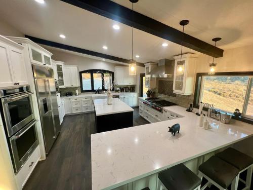 a large kitchen with white cabinets and a large island at Ultimate Winery Getaway With Spa And Amazing Hilltop View in Temecula