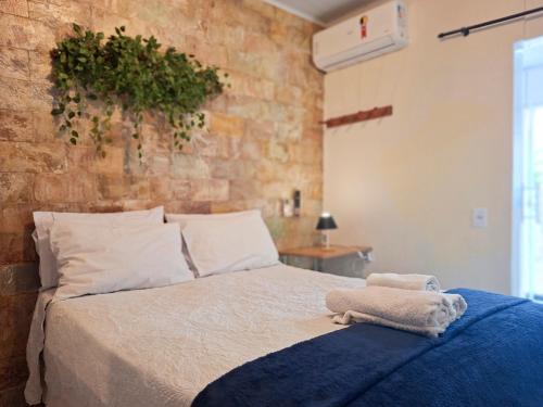 a bedroom with a bed with a plant on the wall at Kitnet Lua - Mobiliada in Belo Horizonte
